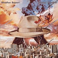 Portada del álbum "Heavy Weather" de Weather Report, con una pintura surrealista de un sombrero flotando en un cielo tormentoso.