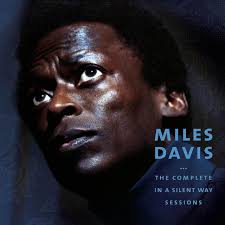 Portada del álbum "In A Silent Way" de Miles Davis, con un retrato en primer plano del músico, en tonos oscuros y mirada introspectiva.