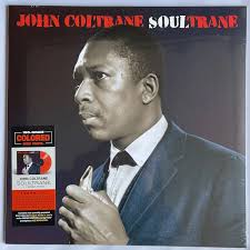 La imagen muestra a John Coltrane tocando su saxofón, capturando la intensidad y espiritualidad de su música.